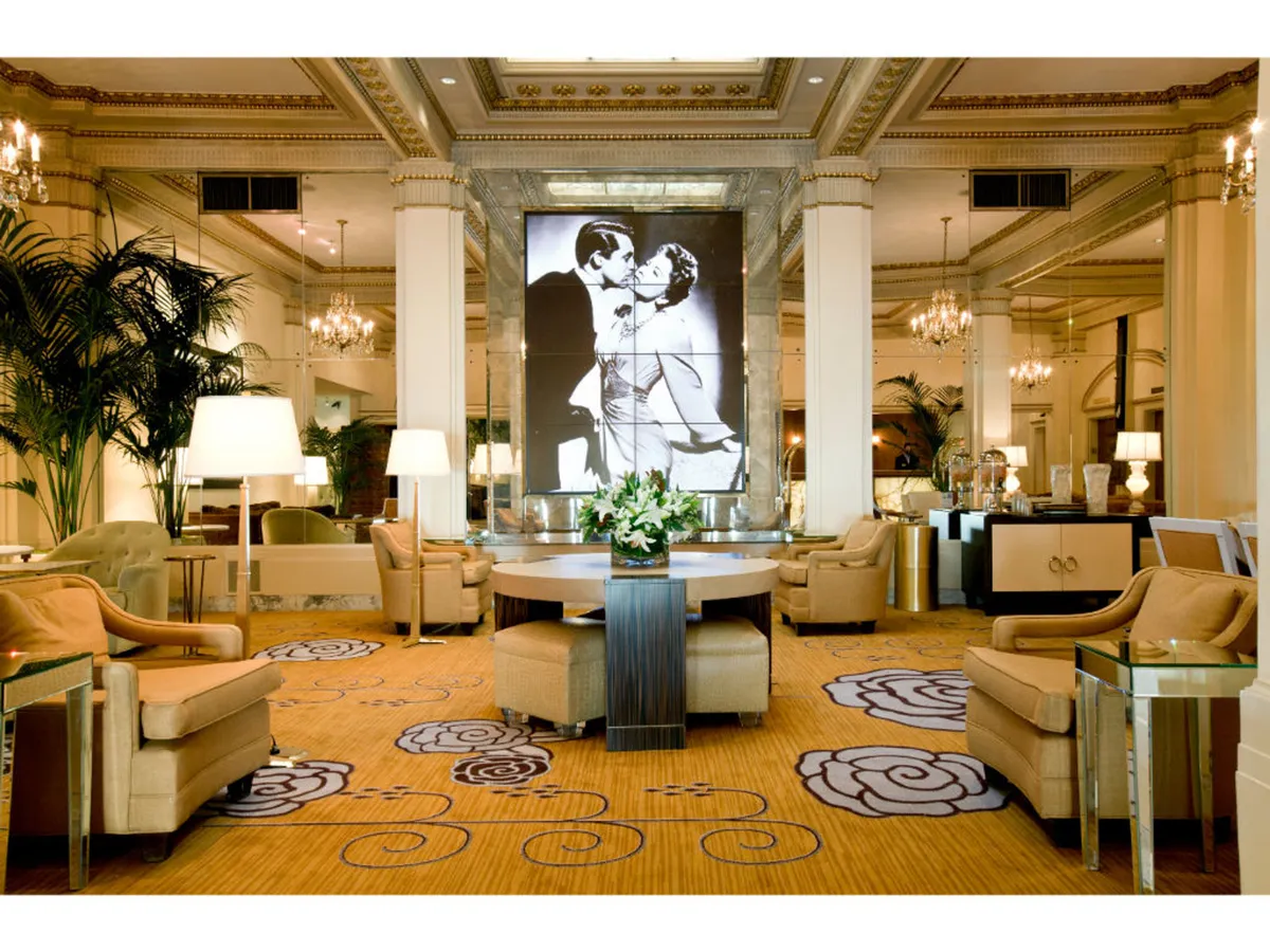 A romantic and sophisticated interior with comfortable seating areas clustered around a central floral arrangement and eye-catching black and white artwork. The space is well-suited for social gatherings, relaxation, or informal meetings, exuding both historic charm and modern comfort.